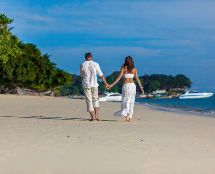 A couple walking hand-in-hand on the beach